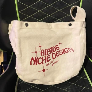 Hiatos Niche Design VINTAGE Väska - Snygg vintage tygväska, använd 2 gånger. Inga fläckar, inte smutsig. Stängs med två knappar, har två sidofickor och en stor. Får plats med laptop och mycket mer, rymmer mycket. Pris går att diskutera vid en snabbaffär, har TVÅ exakt likadana väskor så kolla min andra annons också! Denna är helt oöppnad, de första bilderna är på den andra väskan. Om ni har preferens, meddela det till mig.
