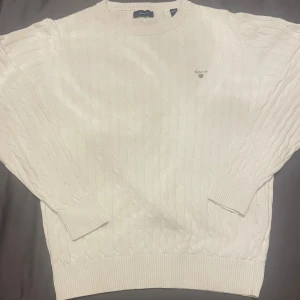 Vit stickad tröja från Gant - Stilren vit stickad tröja från Gant Storlek 146/152, passar perfekt i 11–12 årsåldern. Mjuk och bekväm, inga fläckar eller hål