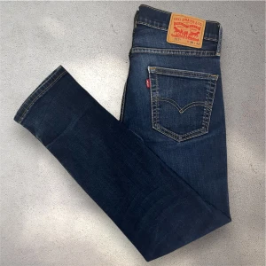 Mörkblå Levi's 511 jeans - Snygga Levi's 511 jeans i mörkblå tvätt med klassiska kontrastsömmar och femficksdesign. Jeansen har en slim passform och är tillverkade i slitstarkt denim. Personen på bilden är 180 cm lång och väger 63 kilo. Skicket är bra förutom att de är lagade i grenen, syns på första bilden. Men det ser man inte när byxorna bärs. Skriv vid frågor!