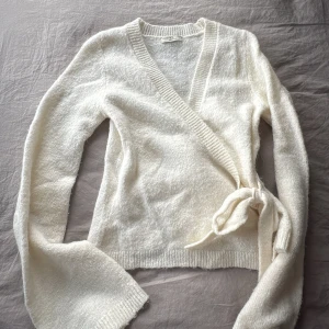 Vit omlottkofta från Gina Tricot - Mysig vit omlottkofta från Gina Tricot med knyt i sidan och ribbade kanter. ❣️❣️