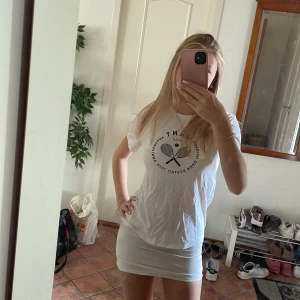 Vit gant T-shirt tennis - Vit t-shirt med svart tryck från Swedish Open Båstad 2017, 70th Anniversary. Klassisk passform med rund hals och korta ärmar. Trycket har två tennisracketar och text runtom. Perfekt för dig som gillar sportig stil.