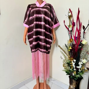  Rosa långklänning med fransar - Unik långklänning i rosa med coolt mönster och breda ärmar. Klänningen har rosa detaljer vid hals och ärmslut samt långa rosa fransar nedtill som ger extra edge. Perfekt för dig som vill sticka ut med en färgstark och trendig look.  Följ oss på Instagram; @shop_with_tyra