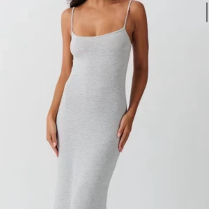 Grå långklänning från Gina Tricot - Supersnygg grå långklänning från Gina Tricot med smala axelband och figurnära passform. Klänningen är ärmlös och har en enkel, stilren design i mjukt material som känns skönt mot huden. Perfekt för dig som gillar minimalistisk stil. Helt ny, endast testad i storlek M!