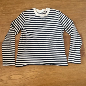 Randig långärmad tröja Carin Wester - Snygg långärmad tröja från Carin Wester i klassiskt marinblått och vitt randigt mönster. Tröjan har rund halsringning med bred ribbad kant och är gjord i mjuk bomull, men lite tjockare i kvaliteten.