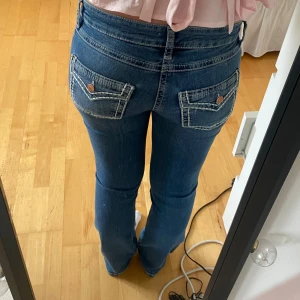 Blå bootcut jeans med sömmar på fickorna - Säljer dessa supersnygga lägmidjade bootcut jeansen med bordering pả fickorna. Bara använda nagon enstaka gäng dà jag inte gillar passformen pa mig. De är fràn Gina Young i storlek 170. Modellen finns inte längre att köpa💖