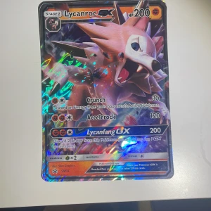 Lycanroc GX - Cool och glittrig Pokémon GX-kort med Lycanroc! Perfekt för samlare och Pokémon-fans som vill boosta sin kortlek med en kraftfull och snygg karaktär. Kortet har unika attacker och en färgstark design som sticker ut i samlingen.