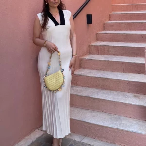 Vit långklänning M NA-KD - Supersnygg vit långklänning med markerad svart v-ringad krage. Klänningen är ärmlös och har en figurnära passform med lätt plisserad nederdel. Perfekt för dig som vill sticka ut med en stilren och elegant look.