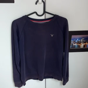 Mörkblå sweatshirt från Gant - En stilren mörkblå sweatshirt från Gant med rund halsringning och diskret logga på bröstet. Tröjan har långa ärmar och ribbade muddar vid ärmslut och nederkant. Perfekt för en avslappnad och snygg look. Pris kan absolut diskuteras!