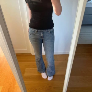 Blå bootcut jeans med låg midja - Snygga blå jeans med bootcut-modell och låg midja. Jeansen har klassisk femficksdesign, dragkedja och knapp framtill. Tillverkade i mjukt denimtyg som sitter för dom super bekväma. Byxorna är från ginatricot. 