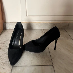 Svarta pumps  - Stilrena svarta pumps från Annabet Zuo med spetsig tå och hög klack. Skorna är i mocka och har en klassisk siluett som ger en elegant vibe. Perfekta för dig som gillar en tidlös. Använt de endast 2-3 gånger, säljer dem på grund av att jag upplever det ostadigt att gå i klackar.
