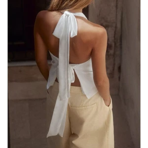 Vit halterneck topp med knytband - Säljer en vit halterneck topp. Helt ny med prislapp!