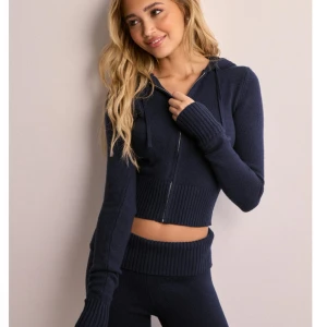 Mörkblå croppad hoodie från Nelly - Mörkblå croppad hoodie från Nelly med dragkedja framtill, huva och snörning. Aldrig använd. Pris går att diskutera 🫶🏻