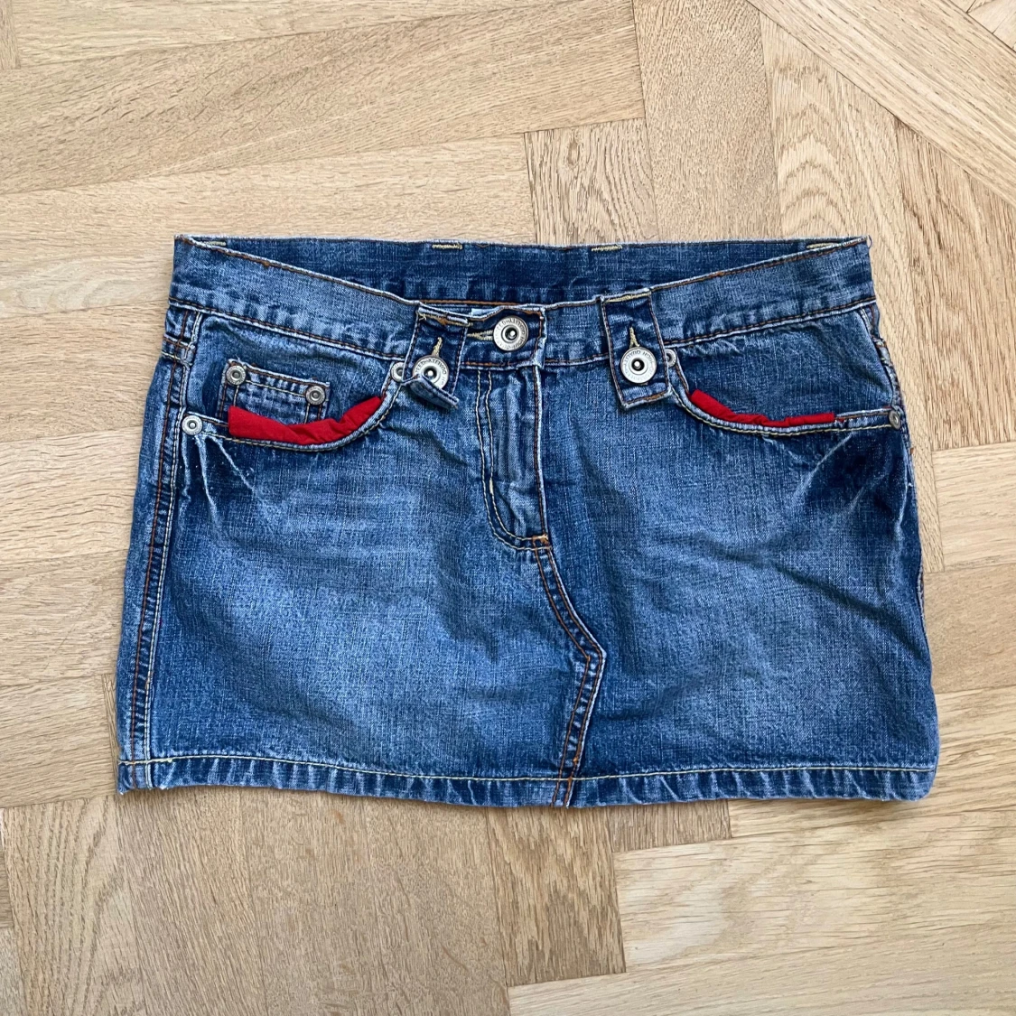 Jeanskjol med röda detaljer