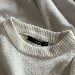 Vit stickad tröja från Bik Bok - Mysig vit stickad tröja från Bik Bok med rund halsringning och ribbade muddar. Enkel att matcha med jeans eller kjol.