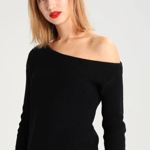 Svart stickad offshoulder-tröja - Säljer en svart stickad tröja med offshoulder-design. Tröjan har lång ärm och ribbade muddar vid ärmslut och nederkant. Perfekt för dig som vill ha en stilren och trendig look.