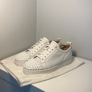 Vita sneakers med nitar från Christian Louboutin - Vita Cristian loubutin med spikar. I storlek 43. De är i bra skick och dustbag medföljer. Pris kan diskuteras.