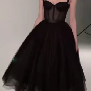 Svart långklänning med mesh och markerad midja - Säljer en svart långklänning med meshdetaljer och markerad midja. Klänningen har en tight överdel med byststruktur och en voluminös kjol i tyll. Perfekt för dig som vill sticka ut på festen! En svart maxifestklänning. Sitter jättefint på kroppen. Ej använd bara provats en gång. Vet inte vad den har för märke, har fått den som en present. 