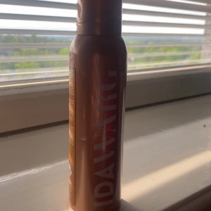 IDA WARG Tinted Self-Tanning Mousse - Brun utan sol-mousse från IDA WARG i nyansen Medium Dark. Ger en solkysst look och är 100% vegansk. Kommer i en brun och guldig flaska på 150 ml, perfekt för att få en jämn och naturlig färg.