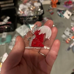 Rött julhalsband med tomteluva - Unikt halsband med en röd tomteluva dekorerad med glitter och vit topp. Perfekt accessoar för att sprida julkänsla. Säljs i förpackning.