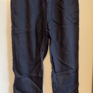 Linnebyxor  - Svarta byxor från H&M i regular fit med resår i midjan. Byxorna har raka ben och är tillverkade i ett lätt material som passar perfekt för vardagsbruk. Klassisk och enkel design utan synliga detaljer.