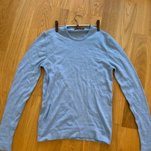 J.Lindeberg blå tröja, storlek S - Säljer min pullover-tröja från J.Lindeberg i mycket bra skick. Snygg och skön, perfekt att ha som den är eller över en skjorta! Inköpt på NK för några år sen, nypris 999 kr. Storlek S, sitter som en XS/S.