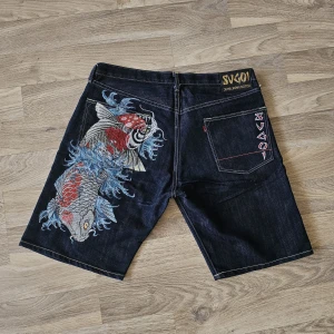 Vintage Sugoi Jeans Shorts - Koi Fish - Säljer ett par shorts från Sugoi Jeans med koi fisk brodering på ena bakfickan, st 38. Skriv om du har några funderingar behöver mått osv (: Midjan = ca 45 cm Längd = ca 54 cm Benöppning = ca 29 cm