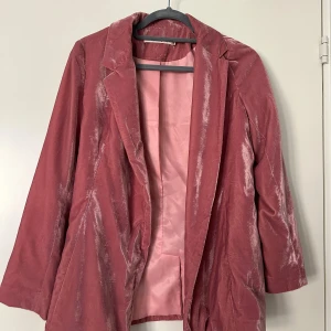 Rosa sammetskavaj från 13plus - Säljer en snygg rosa kavaj i sammet. Kavajen har klassisk krage, lång ärm och är helfodrad i matchande rosa tyg. Perfekt för dig som vill sticka ut med en unik och trendig look.
