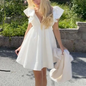 Studentklänning sommarklänning - Lånad första bild, men exakt likadan klänning i nyskick! Vit kort klänning från Showpo, låg i ryggen med rosettknyte. Tyget är lite tjockare, perfekt som studentklänning eller sommarklänning då den inte åker upp! 