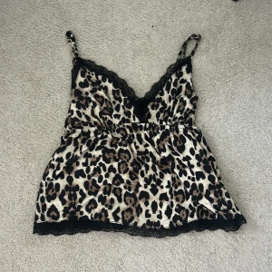 Leopardmönstrad linne med spets - Säljer ett leopardmönstrat linne från Gina tricot med svarta spets och vringad. Säljer den för att jag har aldrig använt den.🥰