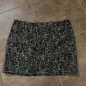 Kortkjol från Kappahl - Säljer en svartvit kjol från Kappahl i storlek 34. Kjolen har ett rutigt mönster och är i en kort modell. Supersnygg!! Helt ny med prislapp på!! 