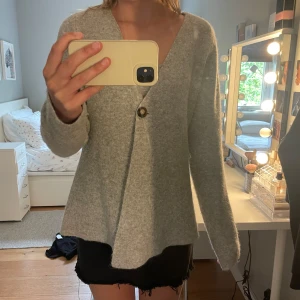 Ljusgrå kofta från vero moda  - Säljer en ljusgrå kofta från vero moda med v-ringning och en knapp framtill. Koftan är långärmad och är sjukt skön. Perfekt för lager-på-lager och enkel att matcha med olika outfits. Sitter mer som en m än en s. Nypris 650 kr ❤️