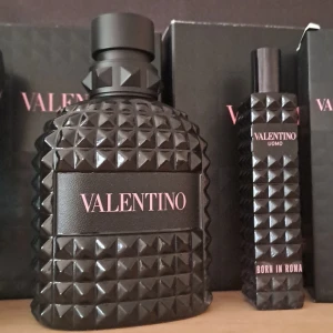 5ml sample av Valentino Uomo Born in Roma Eau de Parfum - Lyxig herrparfym från Valentino i en svart, nitat flaska med rosa text. Doften är modern och elegant, perfekt för dig som vill sticka ut. Flaskan har en unik design med pyramidformade nitar och mattsvart lock.