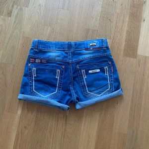 Unika jeansshorts  - Snygga blå jeansshorts med coola flaggdetaljer på bakfickorna. Använd ett fåtal gånger men jag säljer pga att de har blivit för små för mig. Skriv om du har några frågor💕