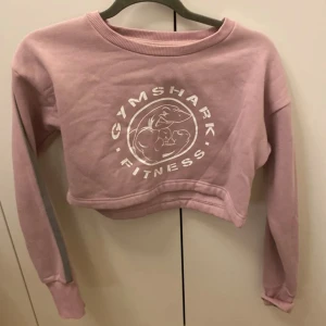 Gymshark croppade tröjor STYCKPRIS  - Säljer flera croppade tröjor från Gymshark i olika färger. Perfekta för träning eller en avslappnad stil. Tröjorna har långa ärmar och är tillverkade i mjukt material. Välj mellan rosa, svart och brun.