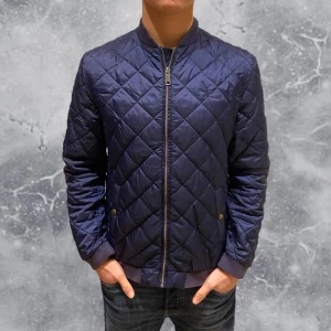 Ralph Lauren Cardigan Jacka Blå - •Ralph Lauren Quiltad Cardigan jacka navy blå. Skick: 8/10, inga skador. Storlek: XL 18-20 ungdom = S~. Sitter bra på modell på bild som är 173 cm & 65 kg. Authentic: ✅. Fräsch & snygg jacka perfekt nu mot våren! Hör av dig vid frågor eller funderingar, mvh Hessler’s;)