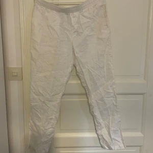 Vita linnebyxor från H&M - Säljer ett par vita linnebyxor från H&M med resår i midjan. Byxorna har en rak passform och är tillverkade i ett lätt och luftigt linnematerial, perfekta för varmare dagar.