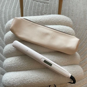Remington plattång med värmeskyddande fodral - Rosa plattång från Remington med digital display och sladd. Kommer med ett beige värmeskyddande fodral med dragkedja. Perfekt för att styla håret rakt eller vågigt. Smidig och lätt att ta med sig.