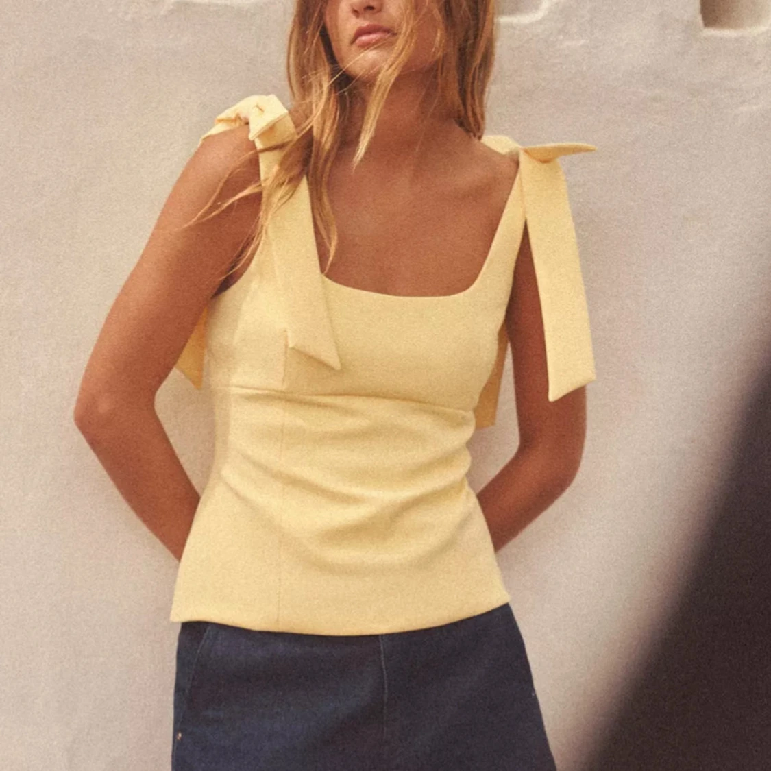 Gul linnetopp med rosetter på axelbanden