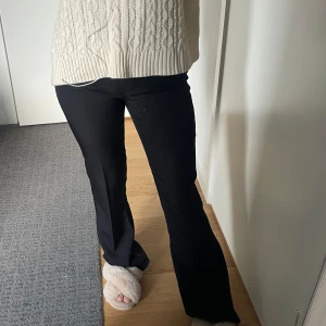 Svarta bootcut-byxor från Boohoo - Säljer ett par svarta bootcut-byxor från Boohoo, helt nya. Byxorna har hög midja och är i ett mjukt, stretchigt material som sitter snyggt över höfterna och låren (110cm). Perfekta till många olika outfits! 