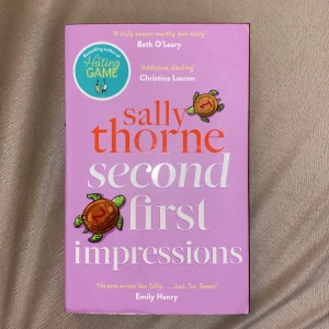 Second First Impressions - Säljer boken 'Second First Impressions' av Sally Thorne. Omslaget är lila med illustrationer av sköldpaddor och text i orange och vitt. Perfekt för dig som gillar romantiska feelgood-romaner på engelska.