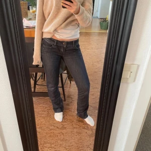 Mörkblå jeansbyxor med normal passform - Säljer ett par klassiska mörkblå jeansbyxor med normal passform och bootcut. Byxorna har låg midja, fem fickor och stängs med dragkedja och knapp. Perfekta till vardags och lätta att matcha med olika toppar.