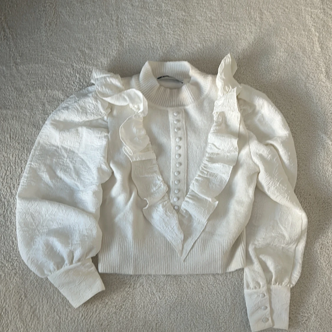 Vit blus med volanger och knappar