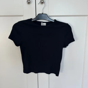 Svart t shirt - En fin svart ribbad t shirt ifrån HM i storlek M, men den är mindre så skulle säga att den egentligen är xs eller s! Super fint skick!