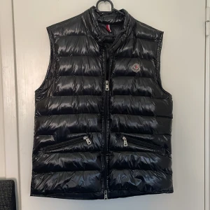 Svart Moncler väst  - Säljer nu denna snygga västen i storlek 3 (M men passar även för S) för ganska bra pris. Inga skador eller fläckar men om du har mer frågot kanske om priset eller västen kan du alltid skriva.