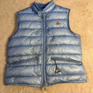 Moncler baby blue gui - Säljer nu min moncler baby blue gui pga av att jag har köpt en ny väst. Västen är en sällsynt moncler väst från 2015(og) storleken är:  2 S/M    Skick: 8/10 -3 små pinholes(syns knappt) pris: 3199kr KOM MED BUD!!!   Köpt på high end Sweden