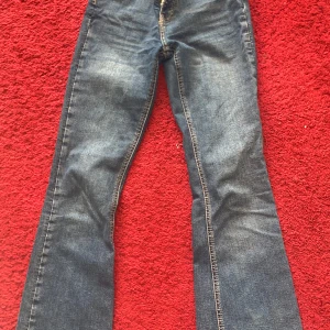Blå bootcut jeans - Säljer ett par klassiska blå bootcut jeans med snygg tvätt och kontrastsömmar. Perfekta för dig som gillar en tidlös stil med lite utsvängda ben. Passar till många olika outfits! 
