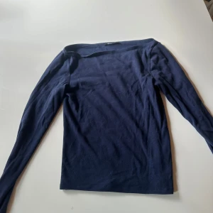 Mörkblå långärmad topp Gina Tricot - Snygg mörkblå långärmad topp från Gina Tricot i mjuk bomull. Modellen har en rak passform och bredare halsringning som ger en chill vibe. Perfekt att styla med jeans eller kjol för en enkel men stilren look.