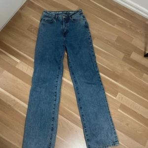 Blå wide jeans regular waist 28/32 - Säljer ett par blå jeans med regular wide passform och midwaist. Klassisk femficksmodell med knappgylf och raka ben. Jeansen har en snygg tvättad look och är tillverkade i slitstarkt denim. Perfekt för dig som gillar lite bredare och avslappnad stil.