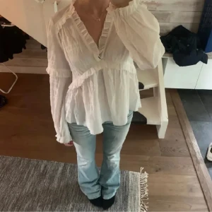 Vit blus med volangdetaljer - INTRESSEKOLL på denna fina blus från NA-KD🤍.  Supersöt vit blus med v-ringning och volangdetaljer längs halsringningen och ärmsluten. Blusen har långärmade puffärmar och en luftig, flowy passform. 💕💕💕🥹