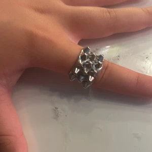 Silvrig ring med nitar - Cool och chunky silvrig ring med flera små nitar som ger en edgy vibe. Perfekt för dig som gillar att sticka ut och vill ha ett statement-smycke. Ringen är bred och har en blank finish som fångar ljuset snyggt. Säljer för halva priset, skriv om du ör intresserad. Skickas idag eller imorgon💞